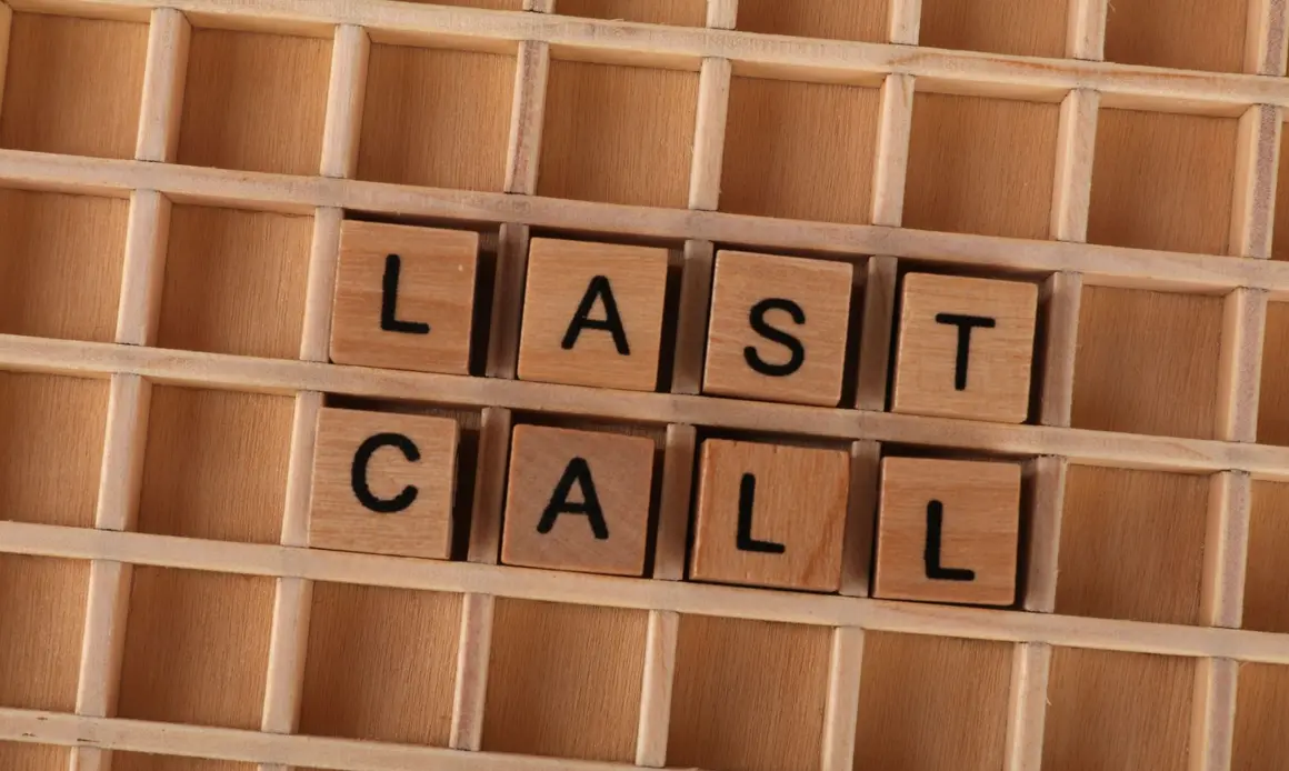Wooden letter tiles forming the phrase 'Last Call' on a wooden background.