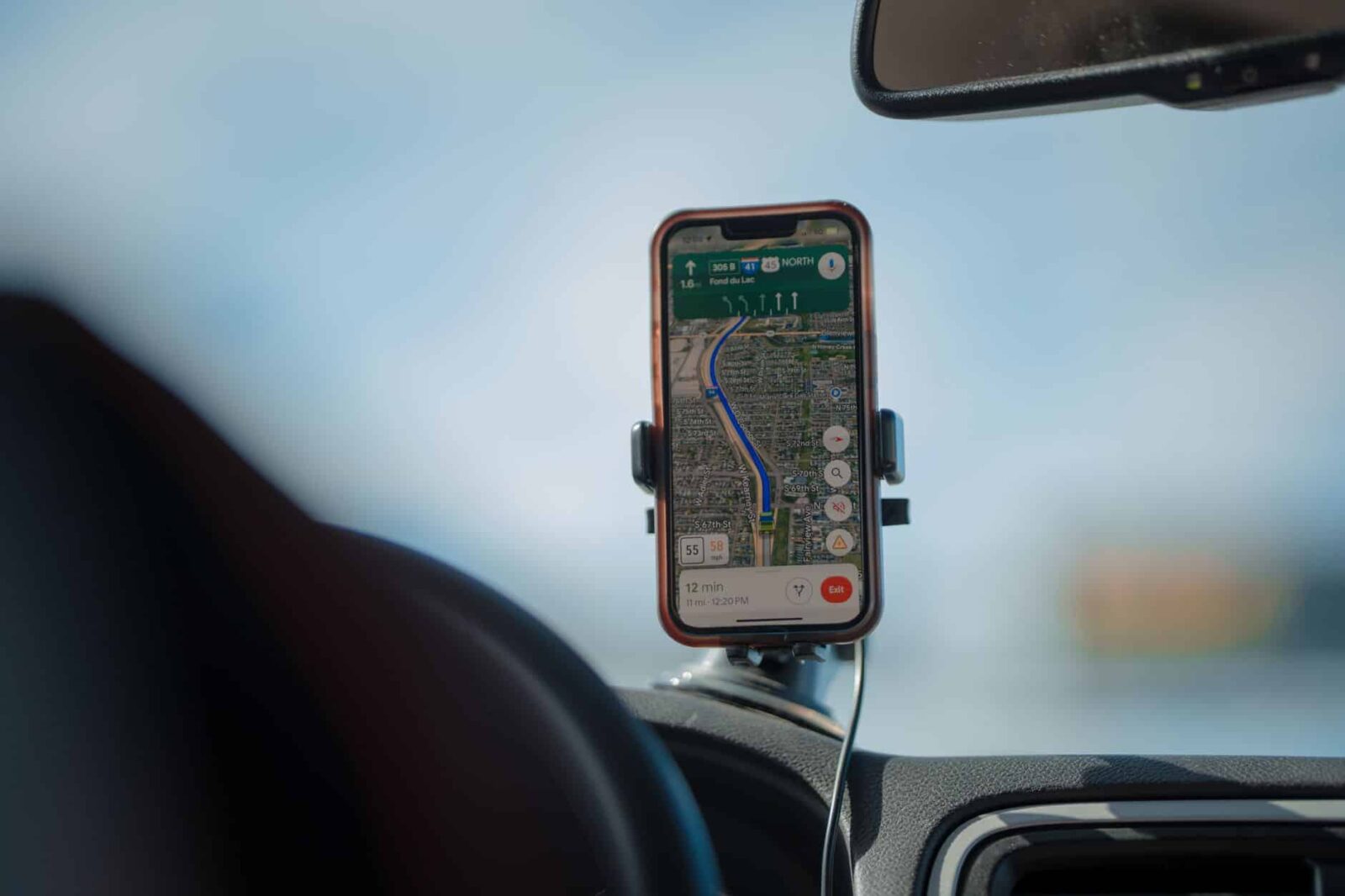 A smartphone with GPS navigation app mounted on a car dashboard during a road trip, cws marketing centennial square