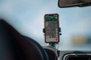 A smartphone with GPS navigation app mounted on a car dashboard during a road trip, cws marketing centennial square