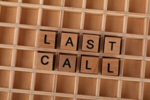 Wooden letter tiles forming the phrase 'Last Call' on a wooden background.